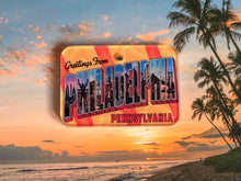 Load image into Gallery viewer, Vintage-style 'Greetings from Philadelphia, Pennsylvania' postcard design dog ID tag with a beach sunset background
