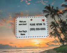 Load image into Gallery viewer, Dog tag with contact information styled in a postcard design against a sunset beach background
